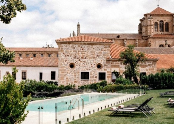 Historic overview of the hotel with grass and pool in front