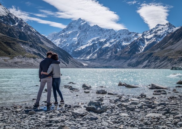 couple gazing out at a lake and mountains