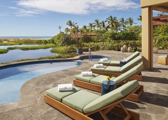 Comfy sun loungers in front of pool and ocean